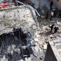 People inspect the wreckage of a house in Kuhestak, Iran, hit by a U.S. missile during a family wedding on Sept. 1.