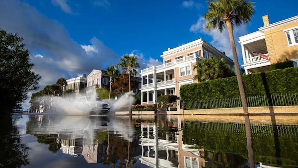 FILE PHOTO A car splashes flood waters on East Battery as a king tide rolls into the historic Battery causing flooding in Charleston, S.C. Sunday, Nov. 15, 2020. (AP Photo/Mic Smith)