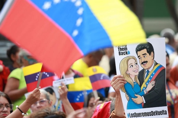 Demonstrators in Caracas hold a banner depicting Venezuelan President Nicolás Maduro and First Lady Cilia Flores with the slogan "Bring Them Back," demanding their release from illegal US imprisonment. Photo: Telesur.