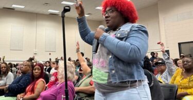 Boxtown resident Alexis Humphreys holds up her asthma inhaler at an April 25, 2025, hearing in Memphis, Tennessee, where residents demanded that officials deny permits for methane gas turbines powering Elon Musk’s xAI supercomputer.
