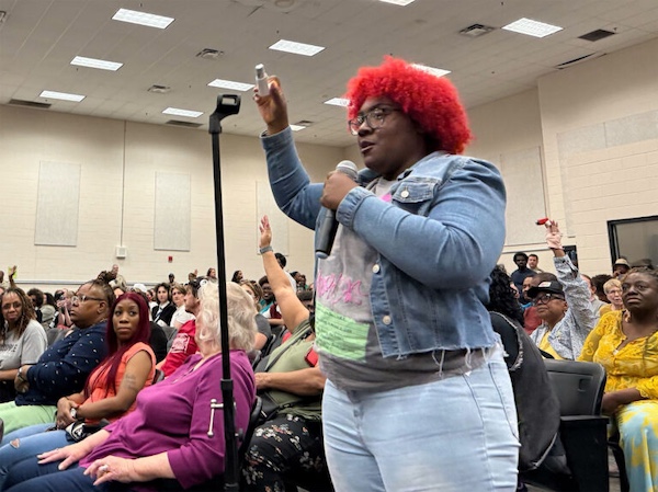 Boxtown resident Alexis Humphreys holds up her asthma inhaler at an April 25, 2025, hearing in Memphis, Tennessee, where residents demanded that officials deny permits for methane gas turbines powering Elon Musk’s xAI supercomputer.