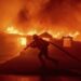 A firefighter battles the Palisades Fire as it burns a structure in the Pacific Palisades neighbourhood of Los Angeles, January 7, 2025