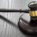 Wood gavel and open handcuffs symbolizing freeing judge decisions